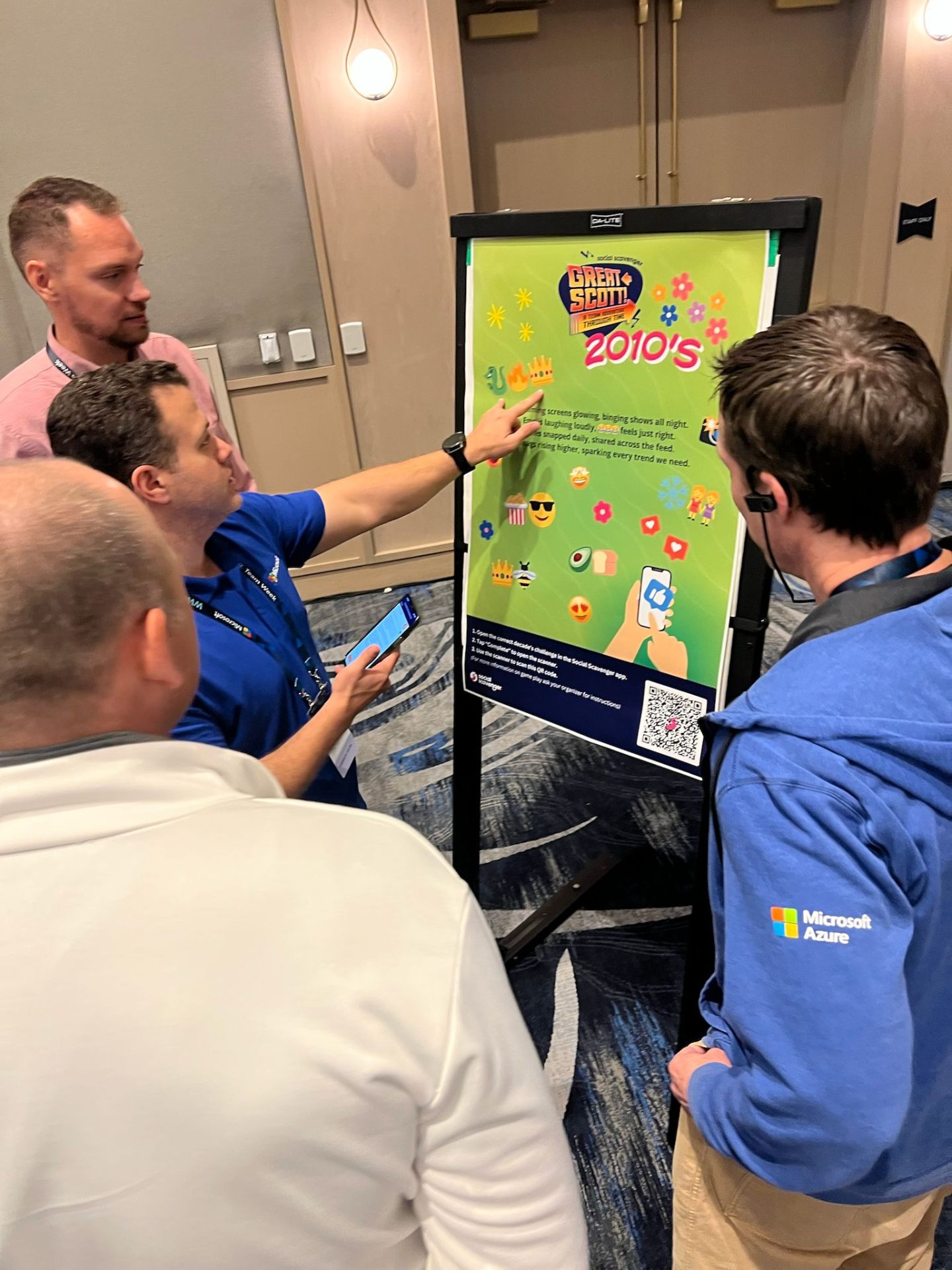 A team of players collaborating around the 2010s decade poster during a Great Scott! game.